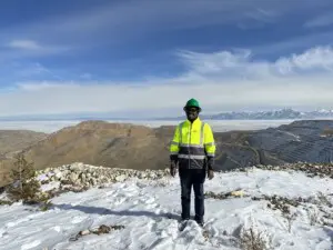 Benedictor Kemanga in Utah, standing in high-vis jacket in snow