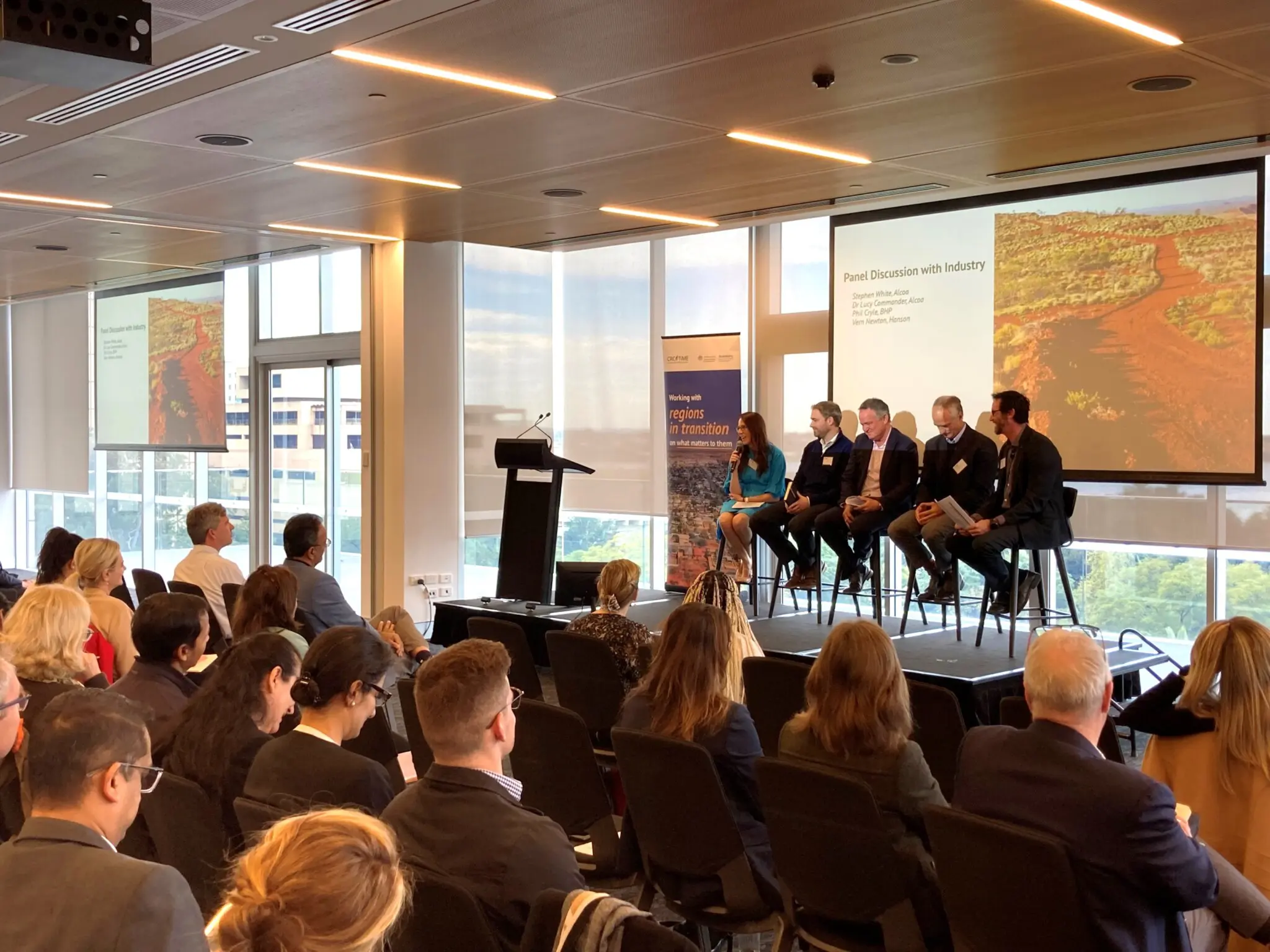 Panel members speaking on stage to audience